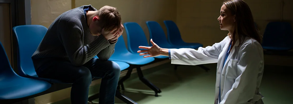 Врач склоняется к человеку в унынии.